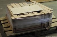 Full pallet wrapped with multiple boxes of porcelain tiles, one tile placed on top for reference