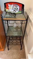 Full view of wine rack with cat plate on top shelf and two wine glasses on lower shelf