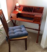 Desk with hutch, leather writing surface extended, chair and cushion visible