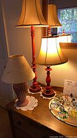 All three lamps on dresser, two red lamps illuminated, pink lamp in front