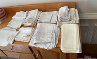 Multiple stacks of folded vintage linens displayed on a wooden surface
