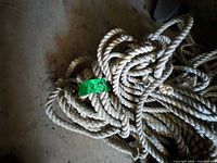 Coiled off-white 3-strand rope with green tag