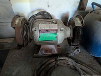 Front view of the bench grinder showing both wheels and overall condition