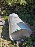 Full view of galvanized steel sheet roll lying on ground