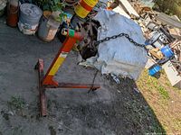 Full view of orange Hein-Werner engine stand holding wrapped engine block