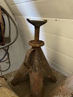 Full view of one rusted screw-type tripod jack stand