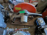 Top view of abrasive chop saw showing orange guard, motor housing, base and surrounding shop equipment