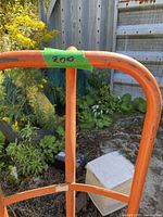 Front view of orange steel hand truck with loop handle
