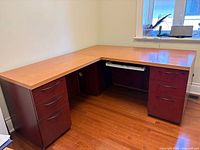 Full view of L-shaped desk showing two-tone finish, keyboard tray, both pedestals