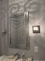 Front view of rectangular beveled wall mirror mounted on wall