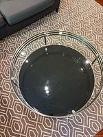 Top view showing clear glass top and black lower shelf within chrome frame