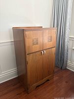 Full front view of cabinet showing twin doors, veneer inlays, handles