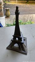 Front view of cast iron book stand shaped like Eiffel Tower