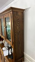 Right side view of oak china cabinet showing wood grain and crown molding