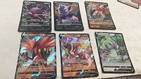 Six Pokémon V foil cards laid out, showing fronts and condition