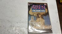 Front cover of Alien Encounters No. 8 in plastic sleeve