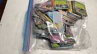 Full bag of loose Pokémon cards inside clear zipper bag