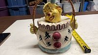 Front view of ceramic clown cookie jar showing lid, handle and painted details