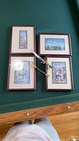 Overview of four framed prints and dagger on table