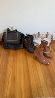 Overall lot showing two pairs of boots, black backpack purse and cream purse