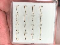 Front view of one display case showing 16 sterling silver hoop nose rings with clear rhinestones