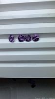 Four round purple amethysts aligned horizontally