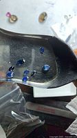 Eight loose blue sapphires on metal scoop