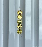 Five round yellow sapphires aligned vertically