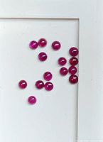All 15 red ruby cabochons grouped on white background