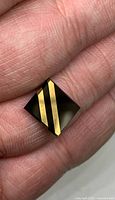 Front view of rectangular black onyx cabochon with two gold-filled diagonal lines