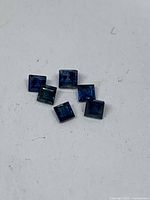 Six square blue sapphires on white background