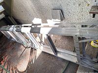 Full length view of aluminum ladder lying on ground outside