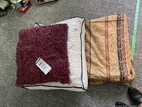 Stack with burgundy pillow, white duvet, folded patterned cover