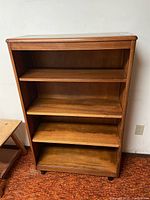 Front view of solid wood bookcase showing four shelves