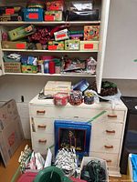 Shelves and dresser with tins, lights, ornaments, wreath, wrap visible
