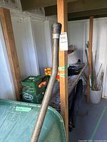 Partial view of hose reel frame, shelving, stakes and bucket