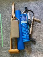 All items grouped: pair of crutches, lumbar cushion, blue foam roller, reach grabber, Accureach massager