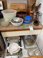 Countertop view showing cutting boards, knife block, salad bowl, mixing bowls, plastic container, salt & pepper mills, garlic roaster