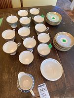 Overall view of cups, saucers, plates and creamer on table