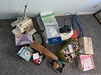 Serger, sewing machine, manual, cords, threads, tins, patterns