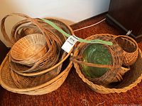 Pile of assorted wicker baskets, green glass insert visible