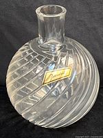 Front view of spherical Baccarat crystal decanter showing swirl cuts and gold label