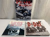 Three hardcover WWII books upright and laid flat