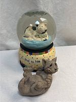 Snow globe and resin cat figurine front view