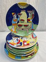 Stack of colourful hand-painted plates with one displayed upright
