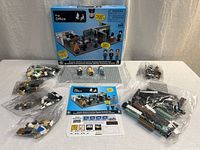 Front view of box with sealed bags, figures, instructions, sticker sheet and base plate displayed