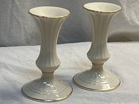 Front view of both Lenox candlestick holders showing ivory porcelain bodies and gold trim