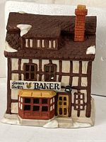 Front view of porcelain bakery building showing sign, snow accents, and bay window