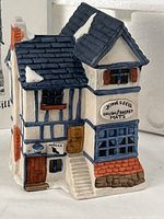 Front view of Dept. 56 Jones & Co. Brush & Basket porcelain building
