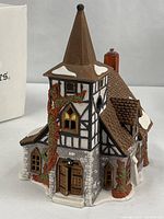 Front view of Old Michaelchurch building showing Tudor design, entrance door, ivy and snow detailing